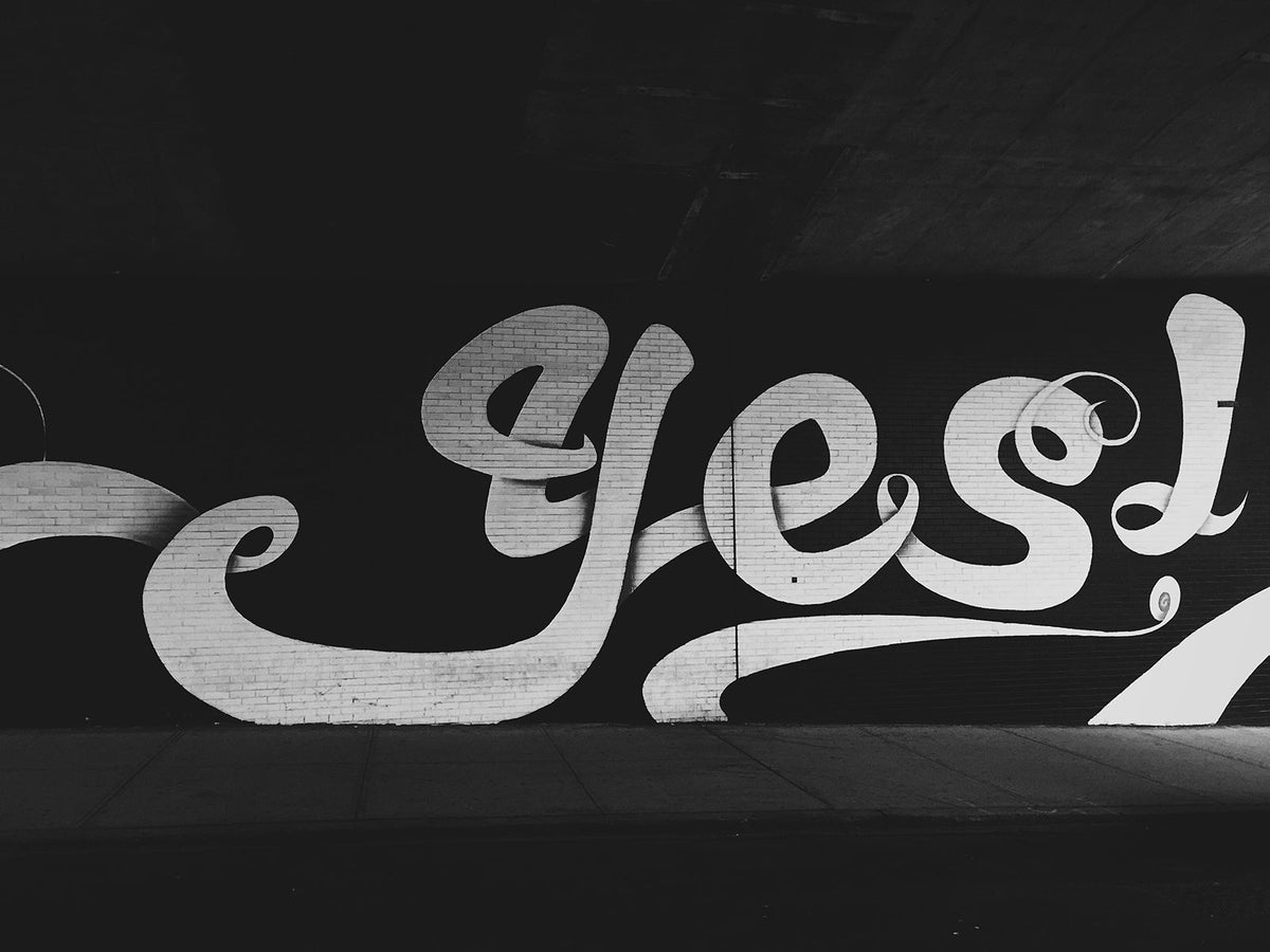 Mural with the word 'YES' in bold white lettering on a black background