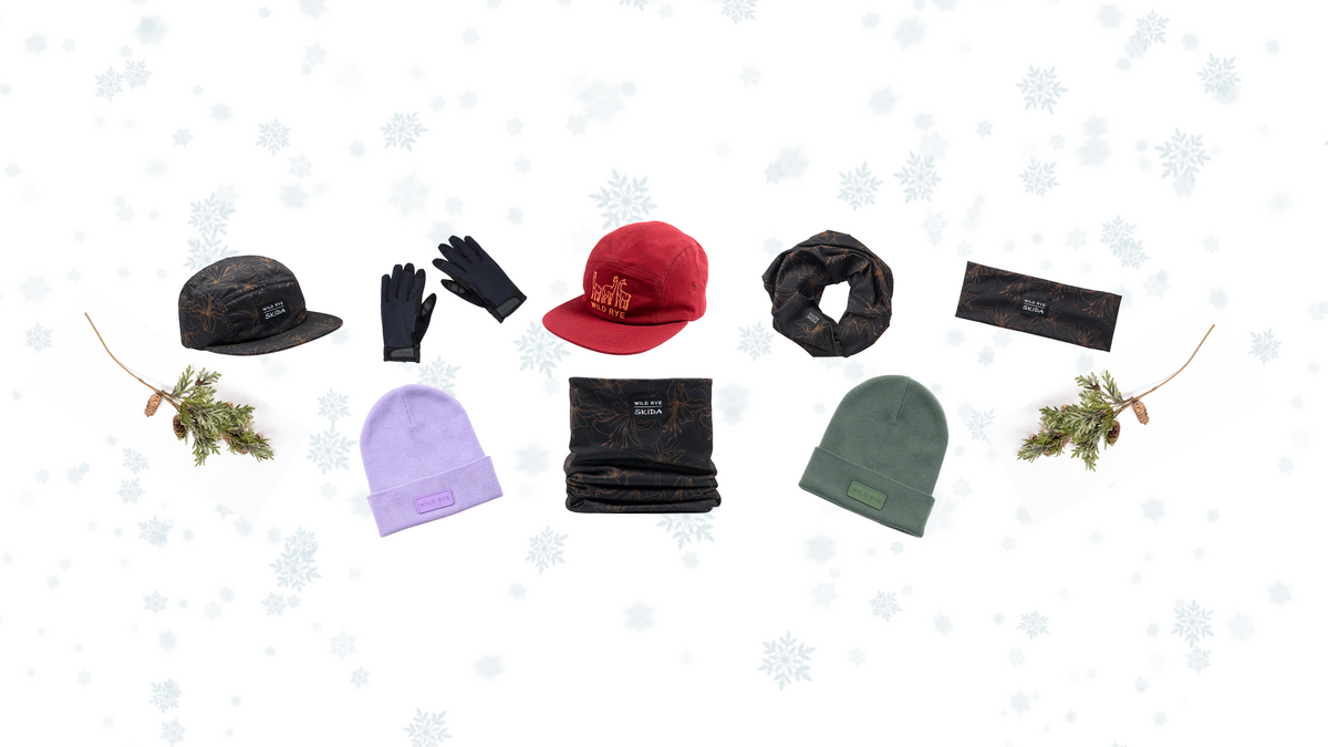 A collection of winter accessories including hats, gloves, and scarves on a snowy background.