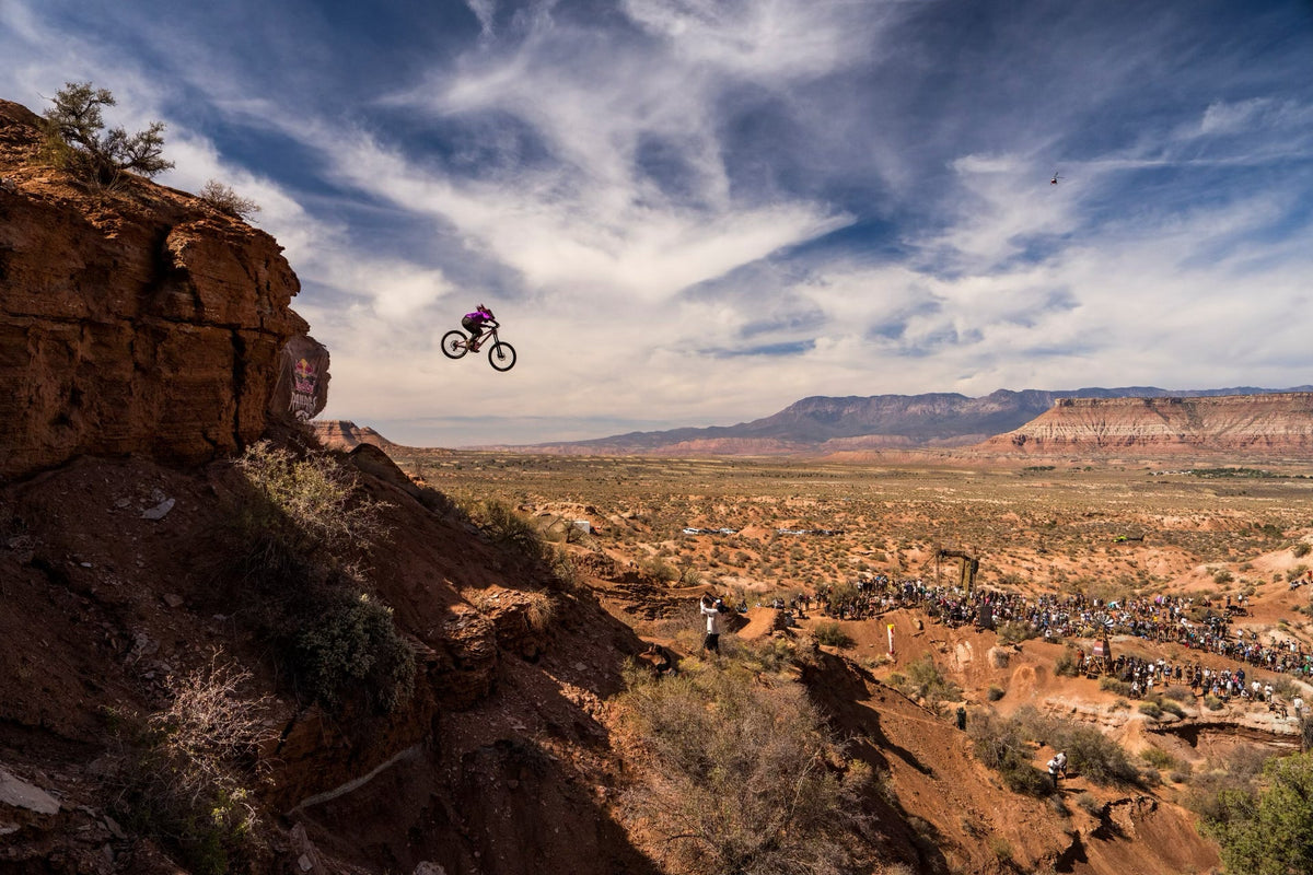 A mountain biker performing a jump over a canyon during Red Bull Rampage.