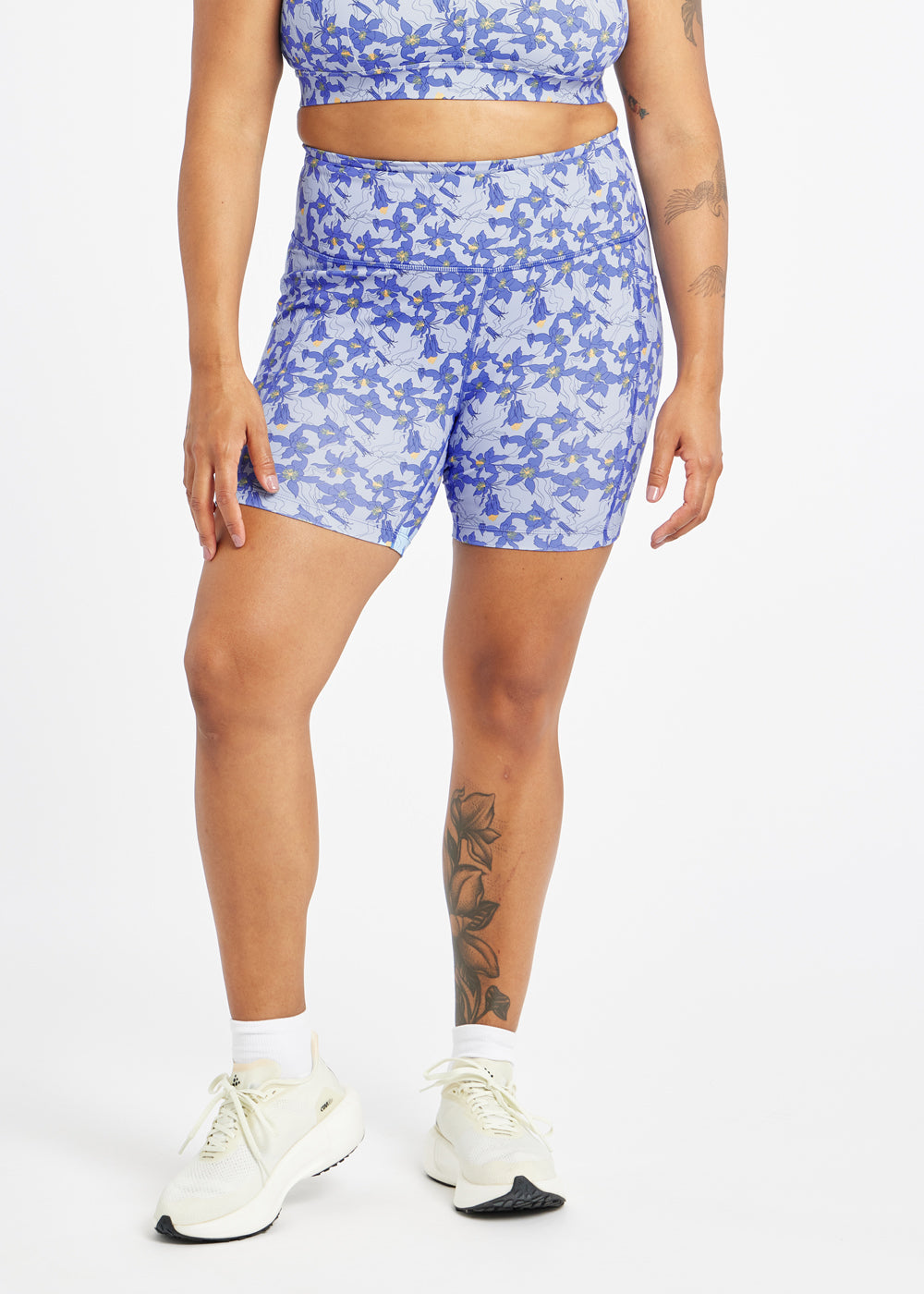 Person wearing a blue floral athletic outfit on a white background