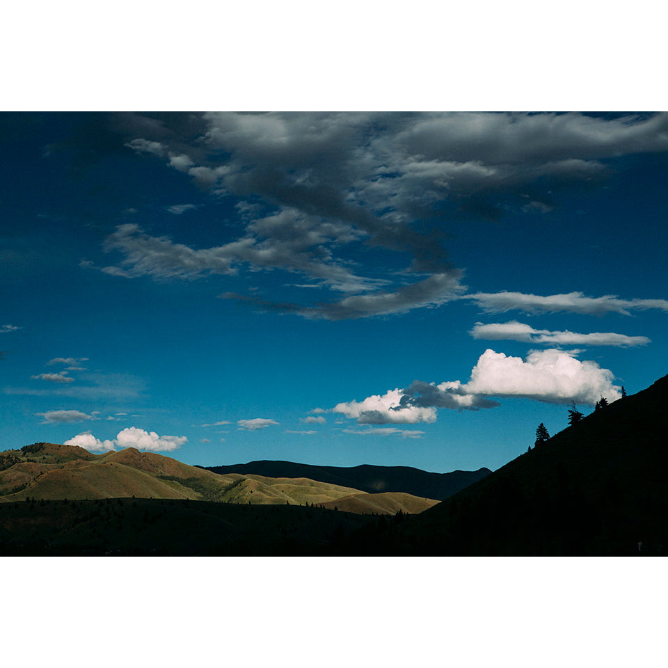 A scenic view of mountains under a blue sky with clouds