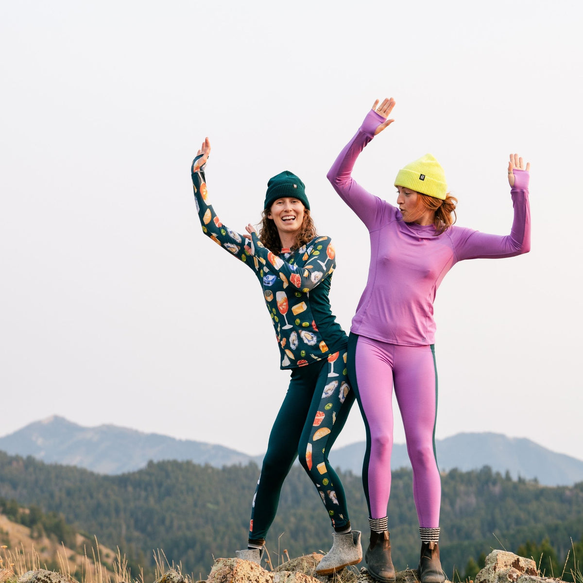[Spruce Spuntini] Two people in colorful baselayer outfits with mountainous background