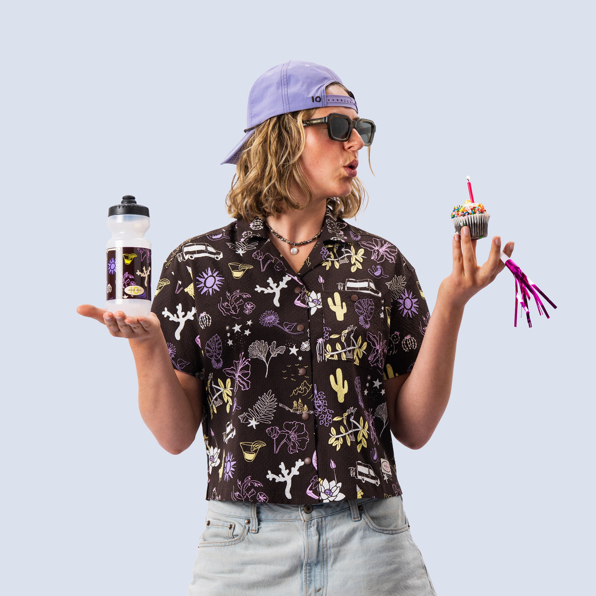 [TEN] Woman modeling various items from the birthday collection and holding the limited edition Bidon bottle