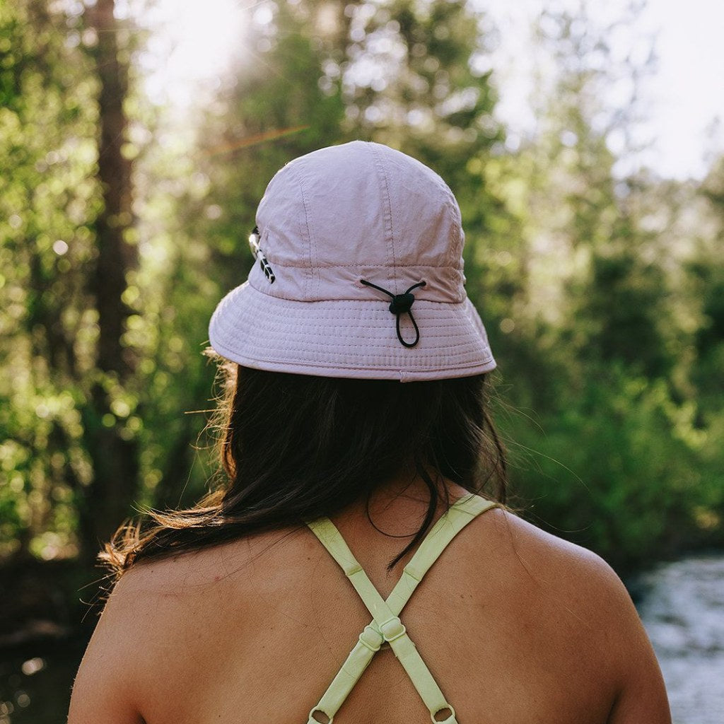 Woman wearing bucky hat on the river, showing back adjustment detail