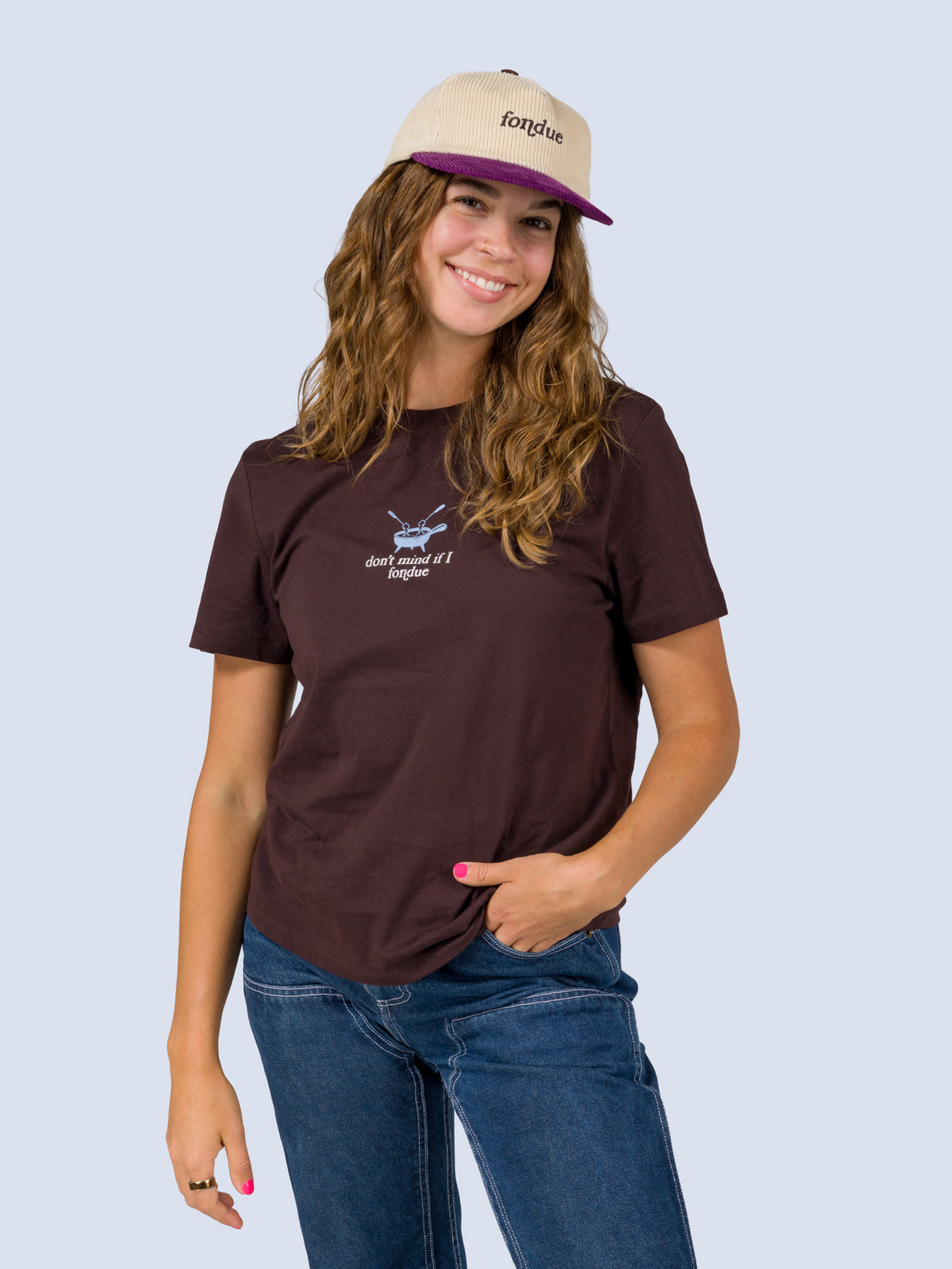 [Fondue] Model wearing the Fondue Graphic Tee in dark brown with a cream and purple Fondue trucker hat, front torso view