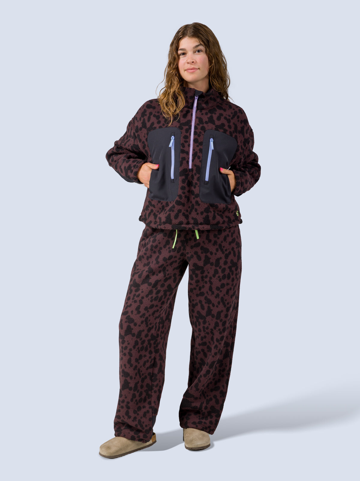 [Dapple] Model wearing the Banner 3/4 Zip Jacket in brown leopard-print fleece with matching lounge pants, full front view