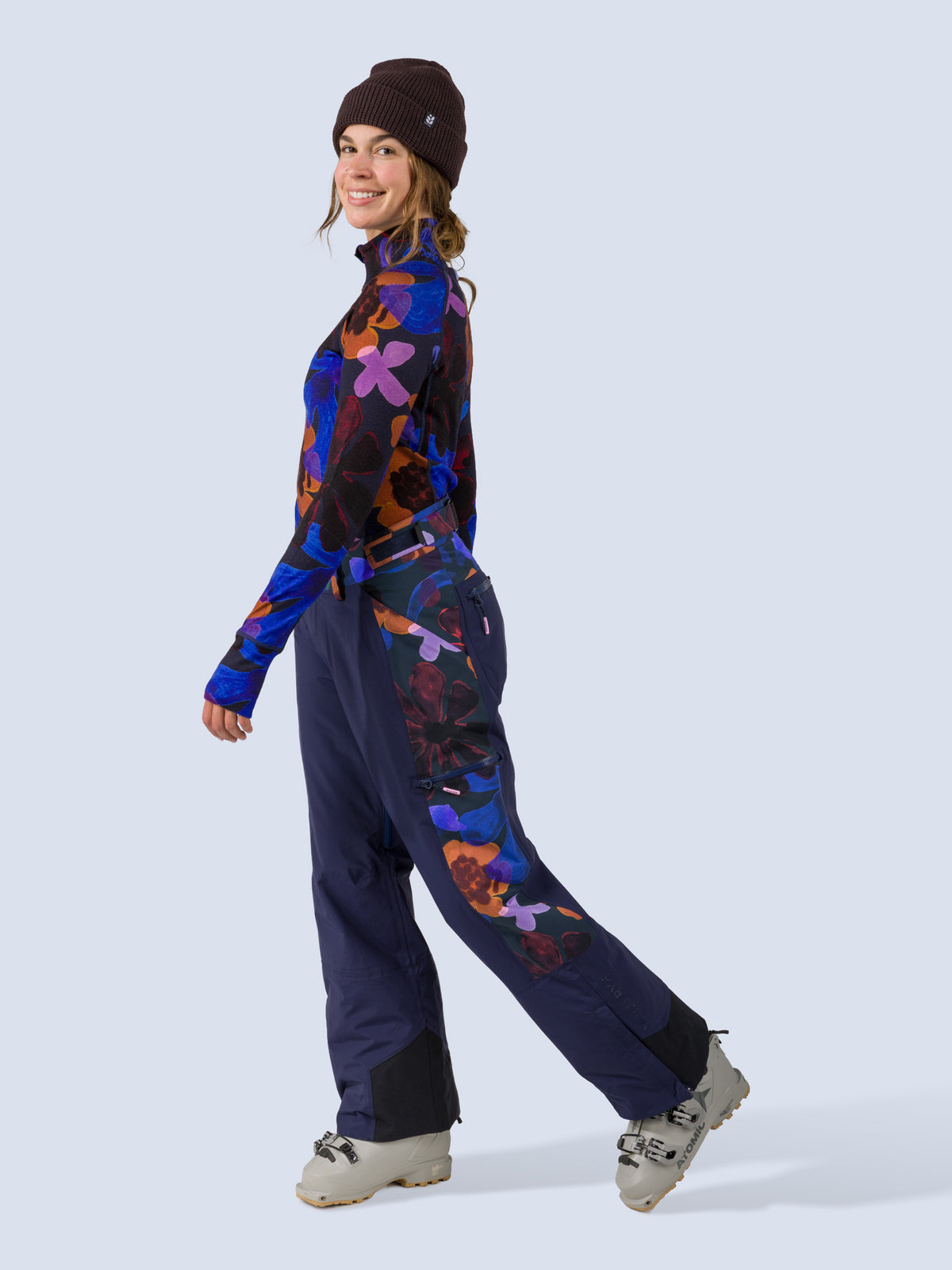 [Nightflora] Roundhouse 2L Insulated Pant in navy with nightflora floral print panels, on model mid-stride side view shot