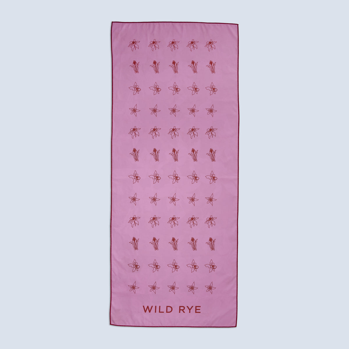 Quick-drying pink towel with red floral patterns and 'Wild Rye' branding