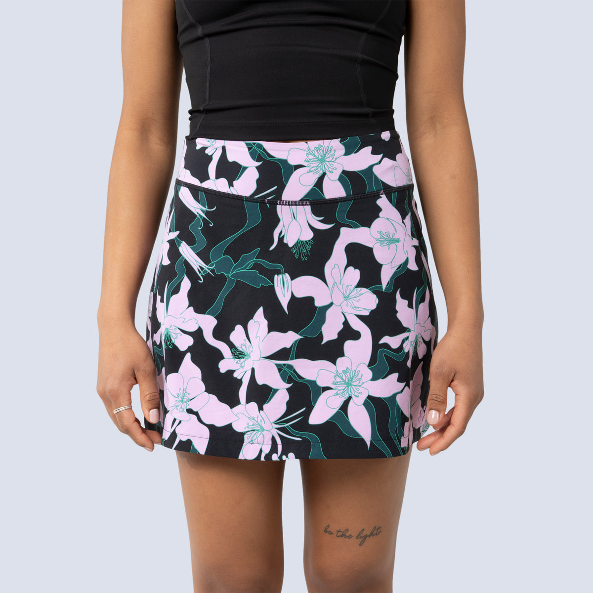 [Black Aquila Bloom] Parker Skort in black with pink floral pattern, on model front crop view