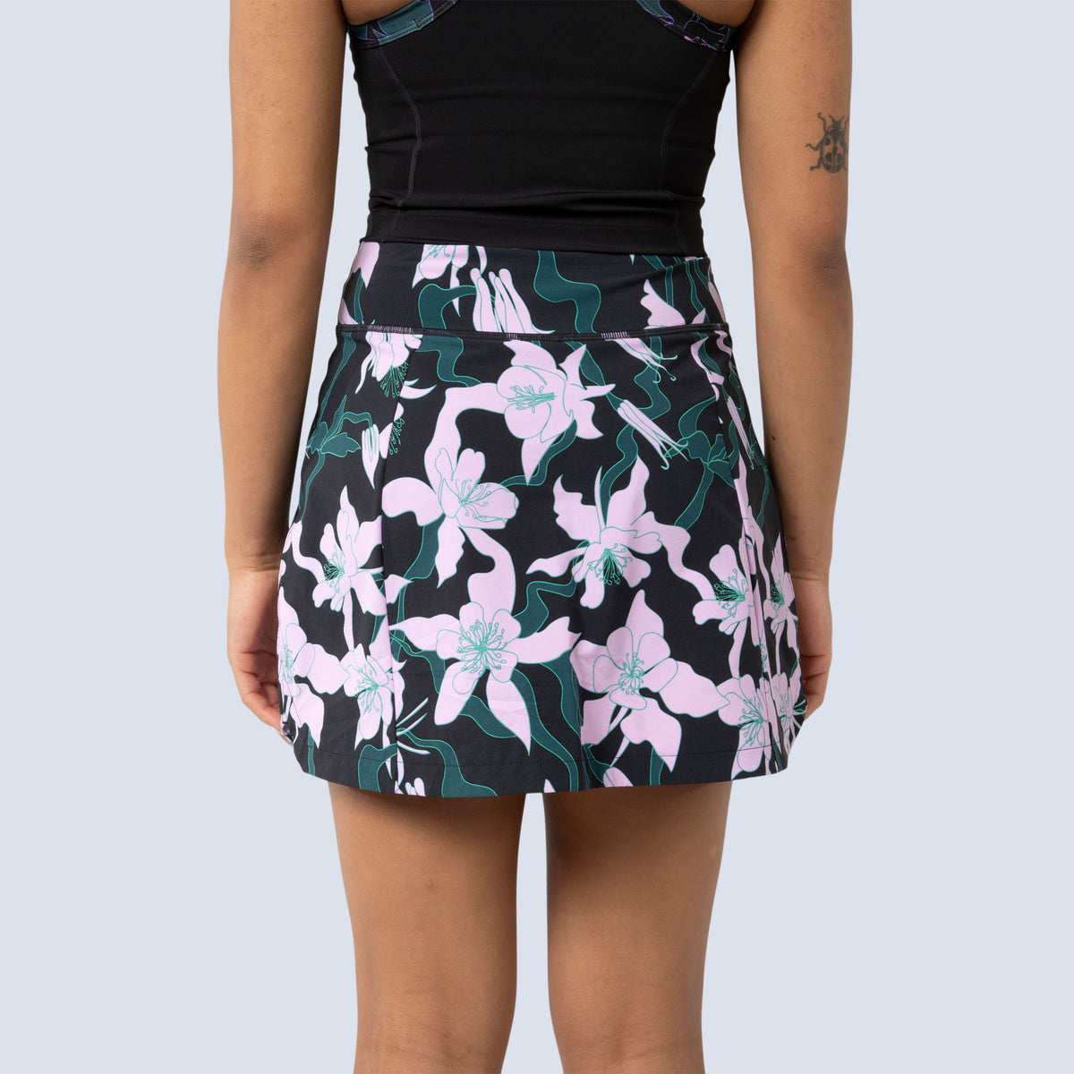 [Black Aquila Bloom] Parker Skort in black with pink floral pattern, on model back crop view