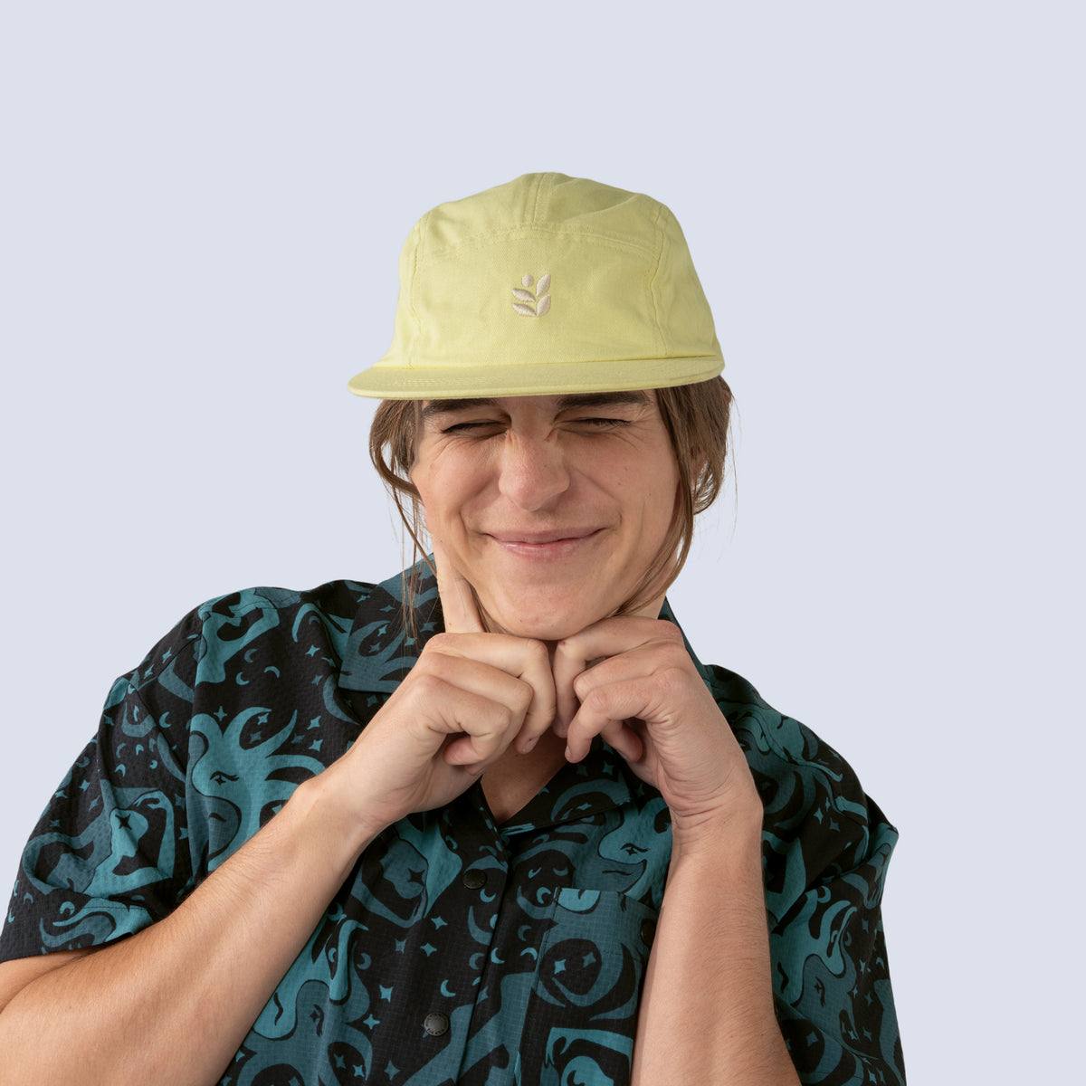 [Butter] Person wearing a yellow baseball hat and patterned shirt against a plain background