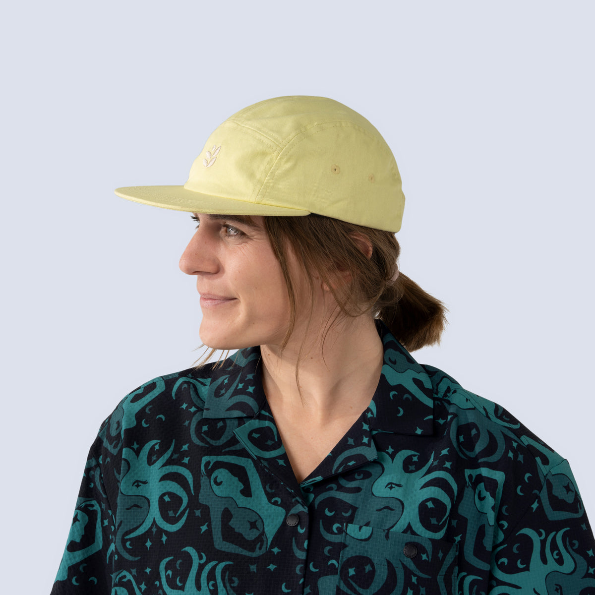 [Butter] Person wearing a yellow baseball hat and patterned shirt against a plain background