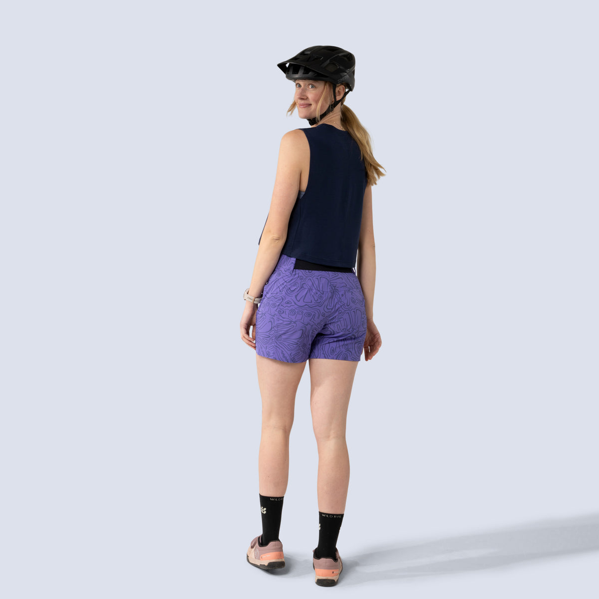 [Midnight] Person wearing a black helmet and midnight keller crop tank, back full body view