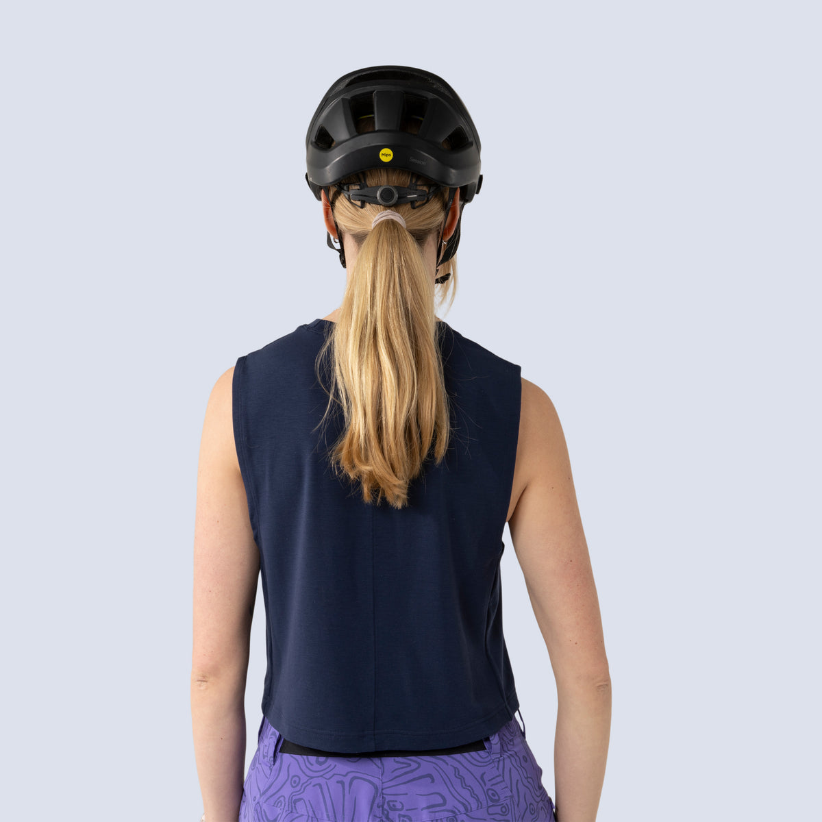 [Midnight] Person wearing a black helmet and midnight keller crop tank, back view