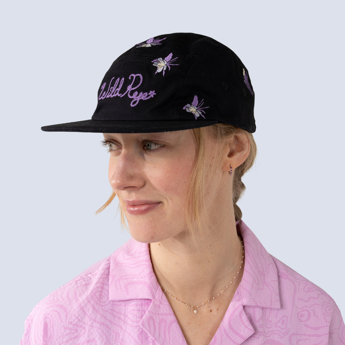 [Black Aquila Embroidery] Person wearing a black baseball hat with floral embroidery on a light gray background