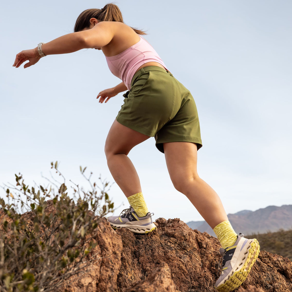 [Olive You] Person hiking on a rocky trail with mountains in the background